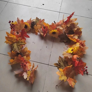 Detailed macro view of autumn garland featuring orange maple leaves and mini pumpkins