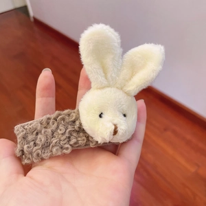Close-up of soft plush rabbit hair clip in cream and brown curly faux fur texture