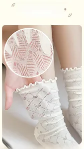 Détail des chaussettes en soie de verre avec broderie de cœur rouge et bords volantés