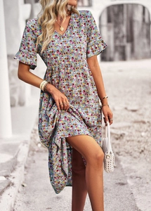 Close-up detail of a V-neck floral print dress with ruffled short sleeves and high waist