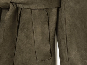 Detail of faux suede coat showing waist tie knot and rectangular pocket in olive brown