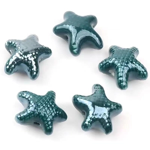 Macro view of five dark green glazed starfish ceramic beads for DIY jewelry making