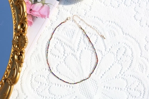 Detail of adjustable gold extension chain and clasp on a colorful rhinestone necklace