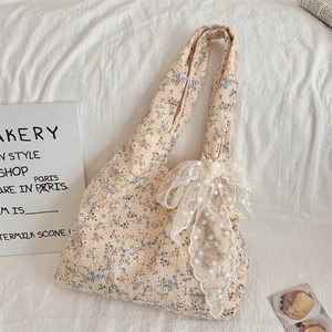 Close-up of floral canvas tote bag featuring delicate lace bow and vintage flower prints