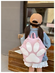 Pink cartoon cat paw backpack for kids shown from the back on a young girl outdoors