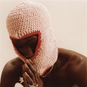 Close-up of pink knit balaclava with red trim and horns for Halloween parties