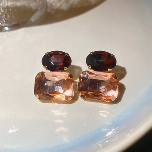 Detailed close-up of vintage style square and oval gemstone earrings in gold settings
