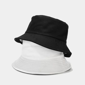 Close-up of black and white cotton bucket hats stacked together with clean fabric texture