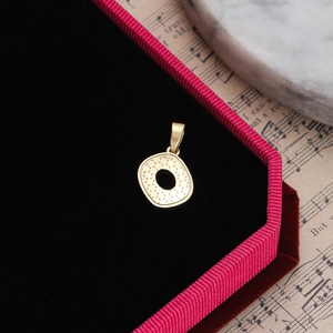 Detailed view of a gold honeycomb texture circular pendant on red velvet lining