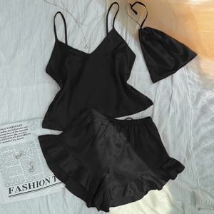 Three-piece black silk satin pajama set with camisole, ruffled shorts, and drawstring bag