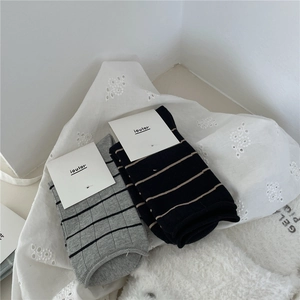 Close-up of ribbed cotton socks in Morandi colors with striped patterns and branded tag