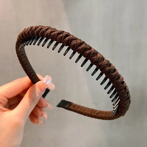 Detailed view of dark brown woven fabric headband with non-slip inner teeth for hair grip