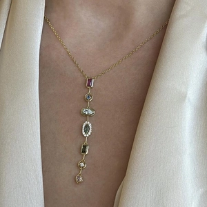 Close-up of golden pendant necklace with multicolored square crystals on model