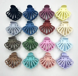 Collection of 16 multi-color matte hollow fan-shaped hair claws in a neat grid display
