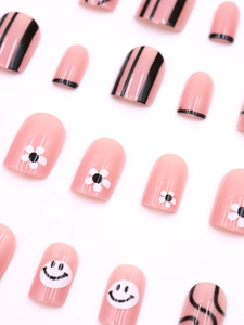 Detailed view of pink press-on nails with daisy flower, smile face, and stripe patterns