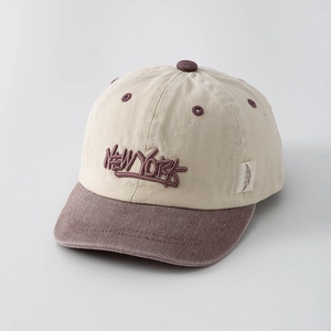 Gros plan sur la broderie New York sur casquette bicolore beige et marron pour enfant