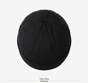Top view detail of the black knitted beanie showing professional ribbed texture and stitching