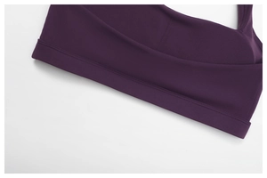 Detail of wide elastic waistband and double-stitched seam on purple yoga sports bra
