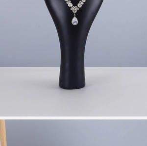 Detailed view of silver necklace with waterdrop pendant on black portrait bust display