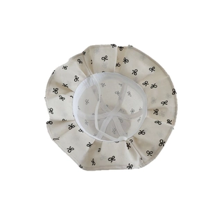 Baby Sonnenhut in Off-White mit schwarzen Schleifenmustern, Rüschenrand und Kinnband