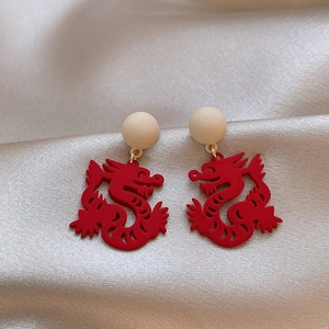 Detailed macro view of Chinese New Year red dragon earrings on a silk background