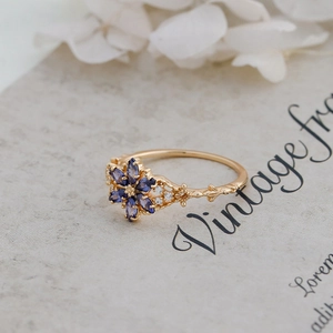 Macro shot of vintage floral ring with marquise blue stones and ornate gold detailing