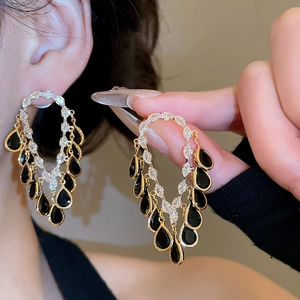 Detail of 18K gold-plated teardrop earrings with black pear stones and sparkling zircons