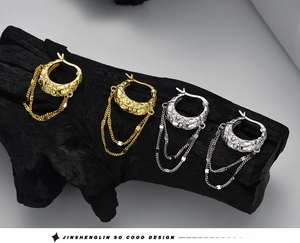 Close-up of gold and silver S925 earrings with lava texture and fringe chains