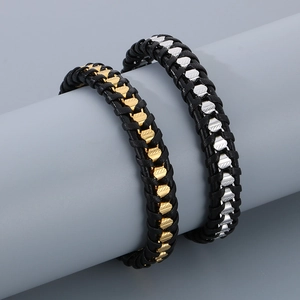 Macro shot of men's braided leather bracelet with textured metal clasp and magnetic closure
