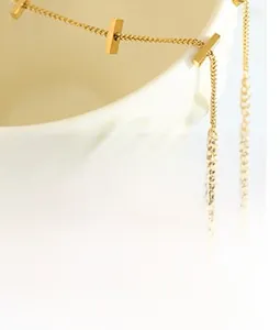 Detailed close-up of a gold-plated textured chain necklace on a ceramic vessel