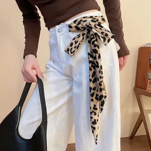 Cintura a foulard in seta con stampa leopardata annodata su jeans bianchi