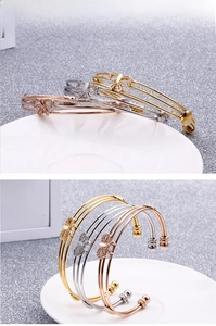 Détail macro de bracelets joncs multicouches avec papillon en cristal en trois couleurs