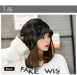 Detail of black lace beanie featuring gold floral embroidery and 3D flower sequins