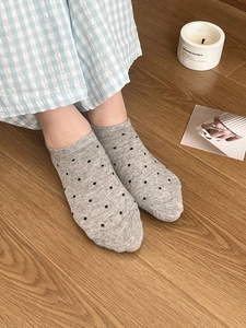 Gros plan de chaussettes grises à pois sur les pieds d'un mannequin avec un décor intérieur