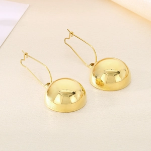Macro detail of polished gold hollow hemisphere earrings with metallic mirror finish
