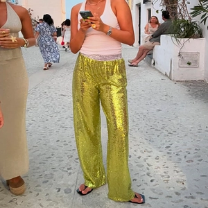Detail of lime yellow sequin wide leg pants with high-waist plaid elastic waistband