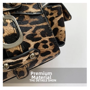 Detail of leopard print leather handbag with silver studs and metal buckle closure