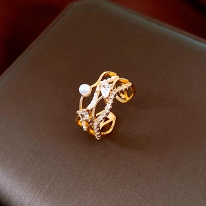 Détail d'une bague multicouche dorée avec perles et zircons sur un écrin à bijoux
