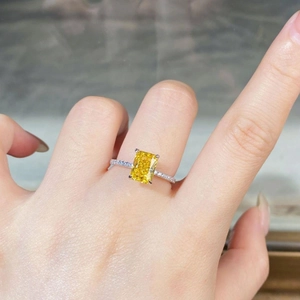 Macro detail of radiant cut yellow gemstone ring with pavé diamonds on a silver band