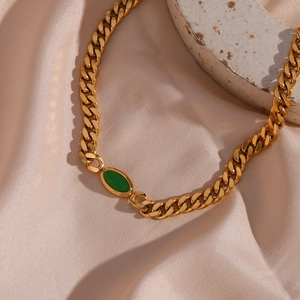 Detail of 18K gold-plated Cuban chain necklace featuring an oval green gemstone pendant