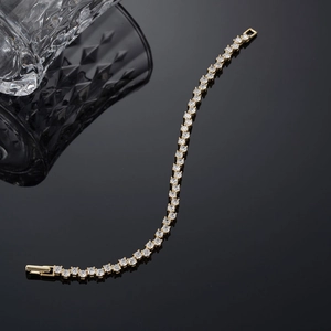 Detailed macro view of a gold tennis chain bracelet with white cubic zirconia stones
