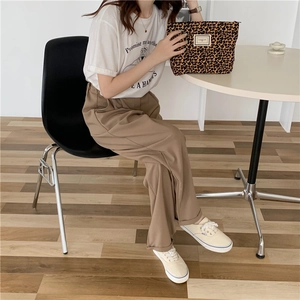 Chic leopard print canvas clutch paired with stylish casual white T-shirt and brown pants
