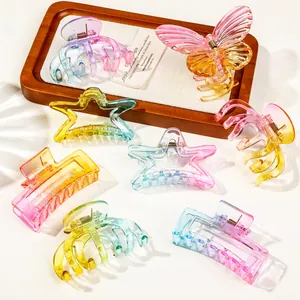 Macro detail of assorted gradient transparent claw clips in butterfly and star shapes
