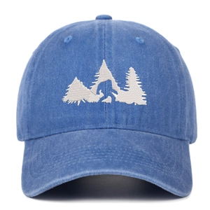 Dettaglio del ricamo Bigfoot bianco su un cappellino da baseball in denim blu lavato