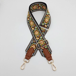 Detail of bohemian embroidery on adjustable canvas strap with gold metal lobster hooks