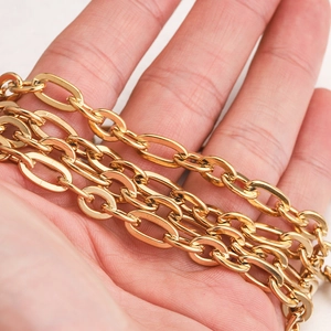 Close-up of gold-plated stainless steel NK Cuban link chain held in hand