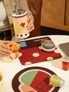 Close-up of heat-resistant mushroom coaster with red polka dots and matching thermal mug