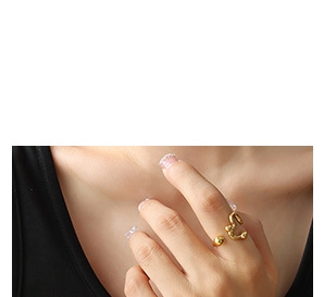 Detailed close-up of a golden irregular twisted open ring with a brushed metal texture
