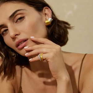 Close-up of model wearing two-tone gold and silver stainless steel geometric earrings