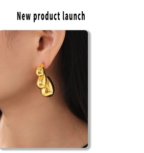 Detail of gold teardrop earrings with triple-layered liquid metal design on model